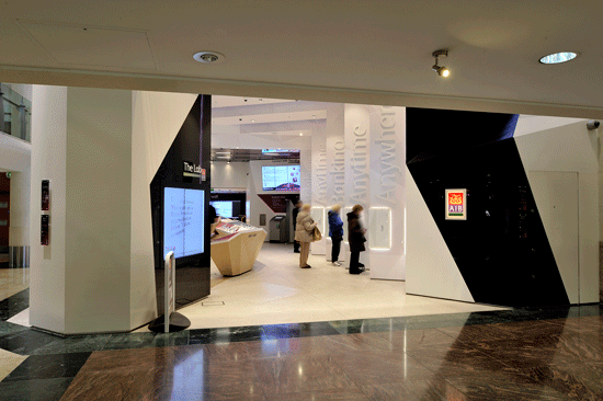 Kunden im Eingangsbereich der Bankfiliale an modernen SB Geräten