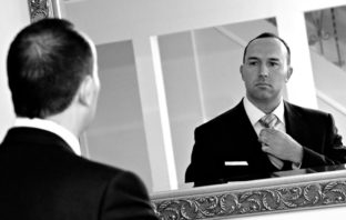 Ein Bankmanager vor dem Spiegel